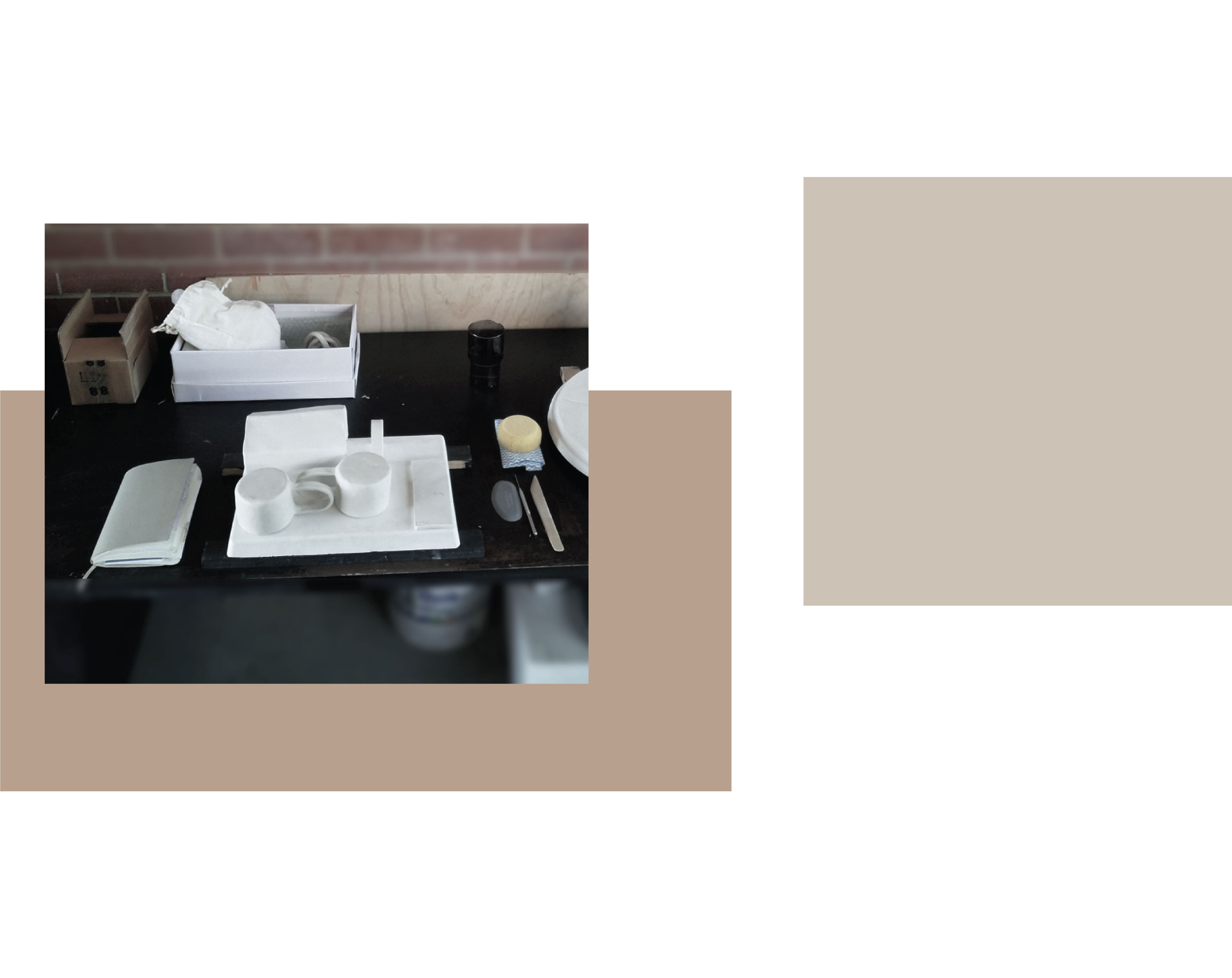 escritorio de estudio con bate de yeso, cuaderno de bocetos, dos tazas de arcilla seca.